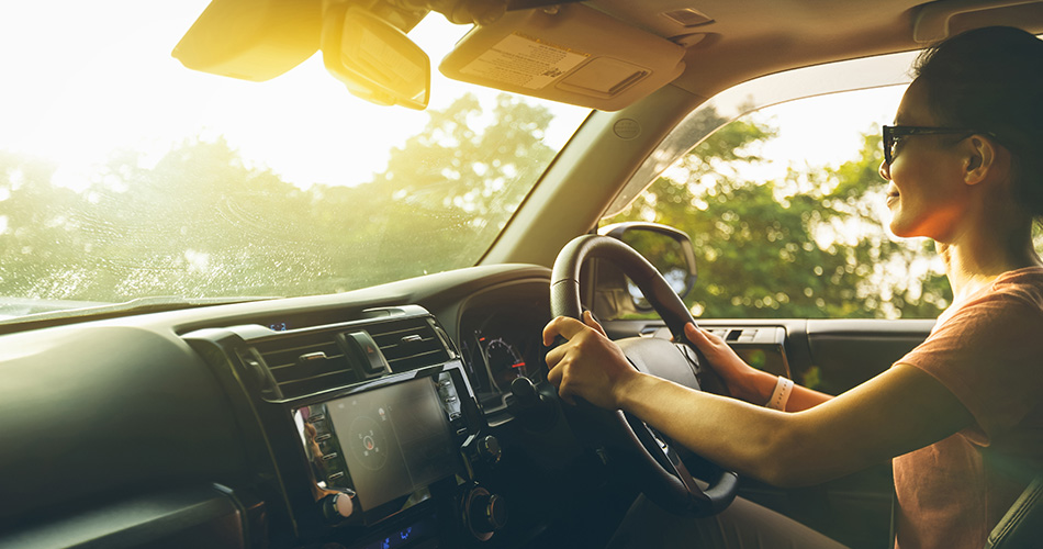 Happy woman driving at sunset
