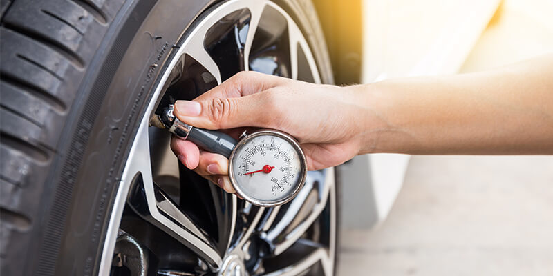 Someone checking tyre pressure